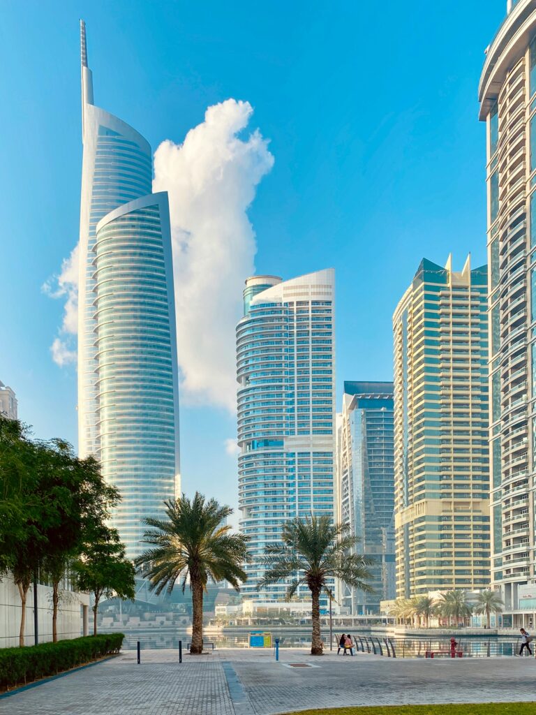 Contemporary skyscrapers with glass facade in an urban setting under a clear blue sky.